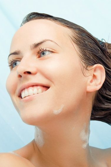 mulher passando creme no cabelo molhado