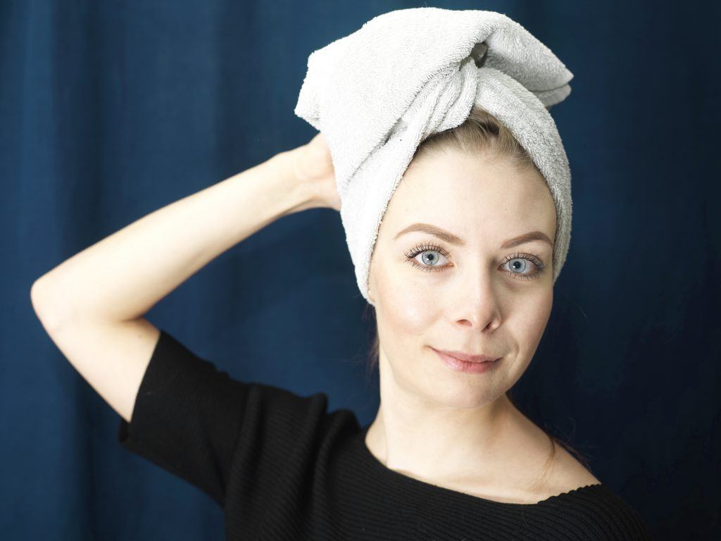 Modelo com toalha na cabeça para secar o cabelo
