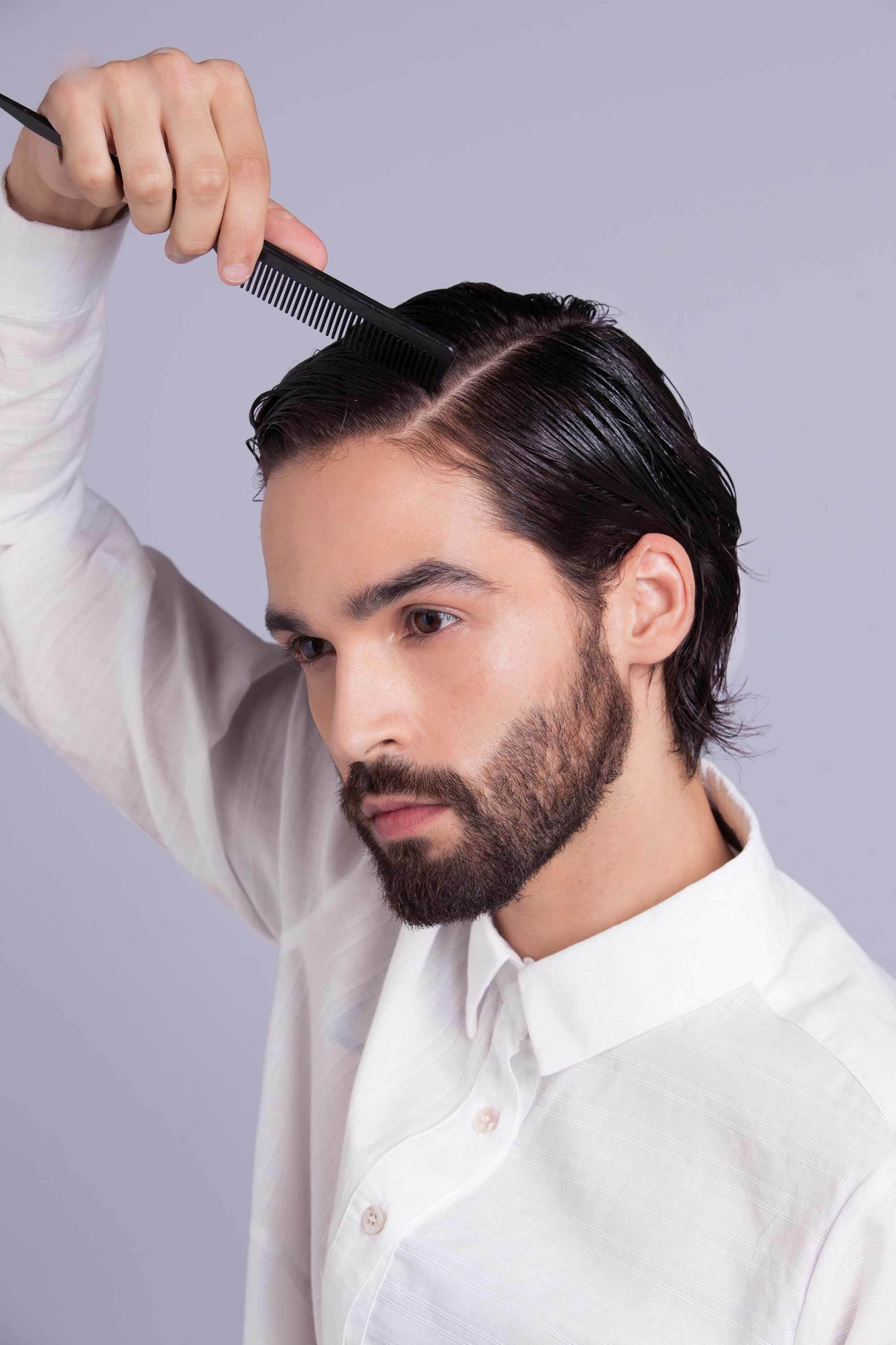 homem com cabelo liso preto penteado para o lado