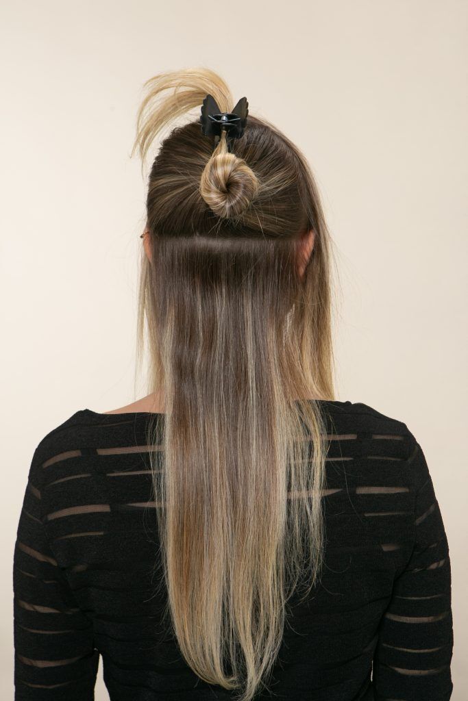 Modelo prende parte do cabelo com presilha
