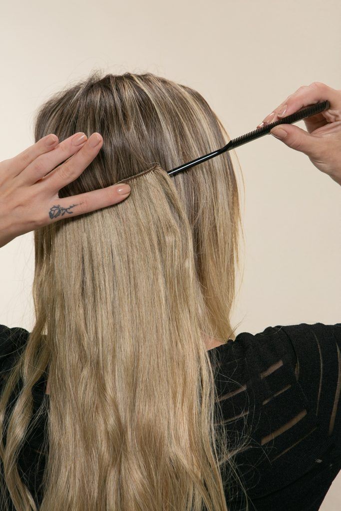 Modelo posiciona o aplique de tic tac no cabelo