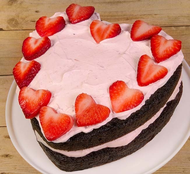 Heart shaped ice cream cake decorated with strawberries.