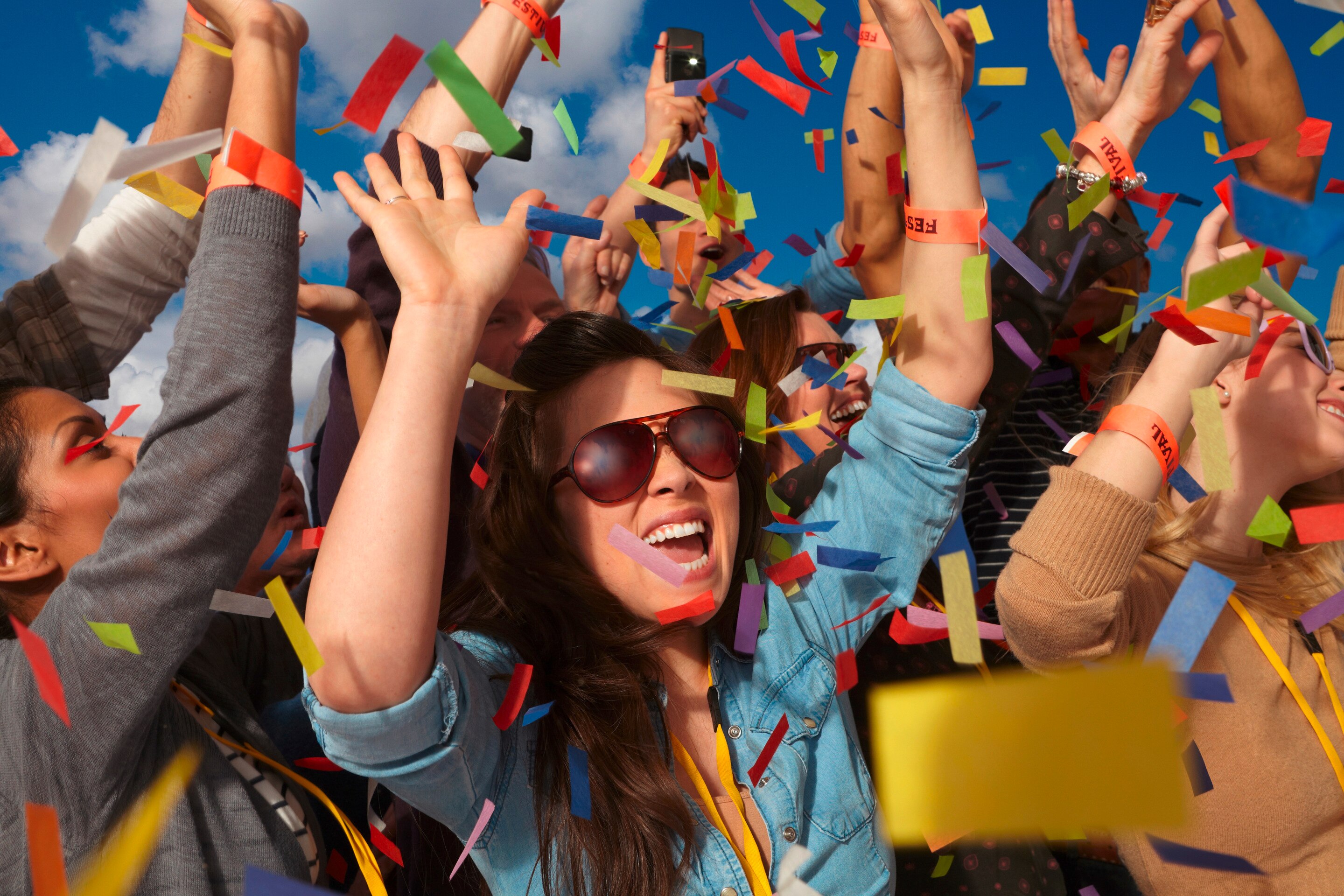 Asian woman cheering at music festival.