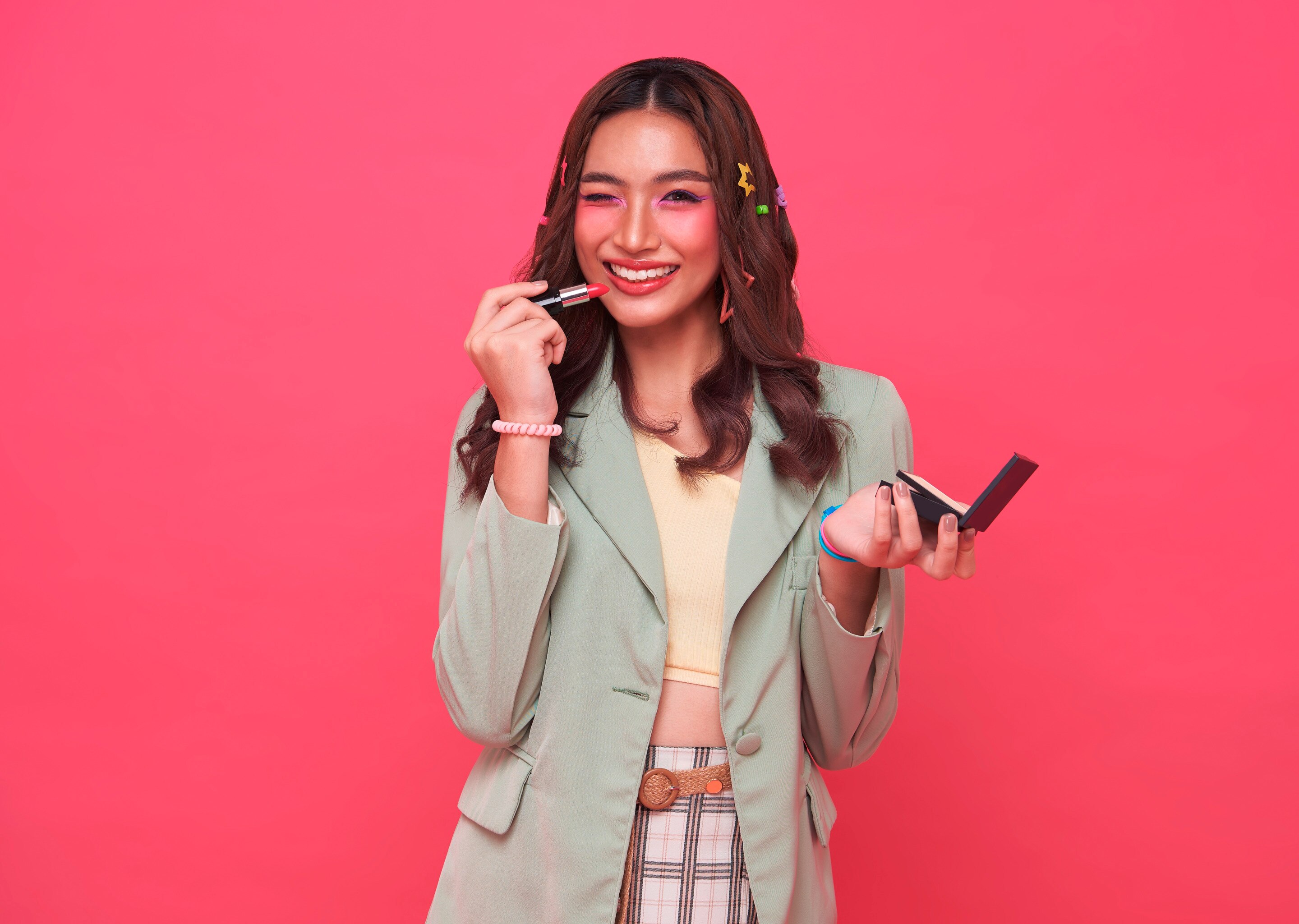 สาวเอเชีย ผิวขาวเหลือง ถือลิปสติก แต่งหน้าโทนสีชมพูม่วง