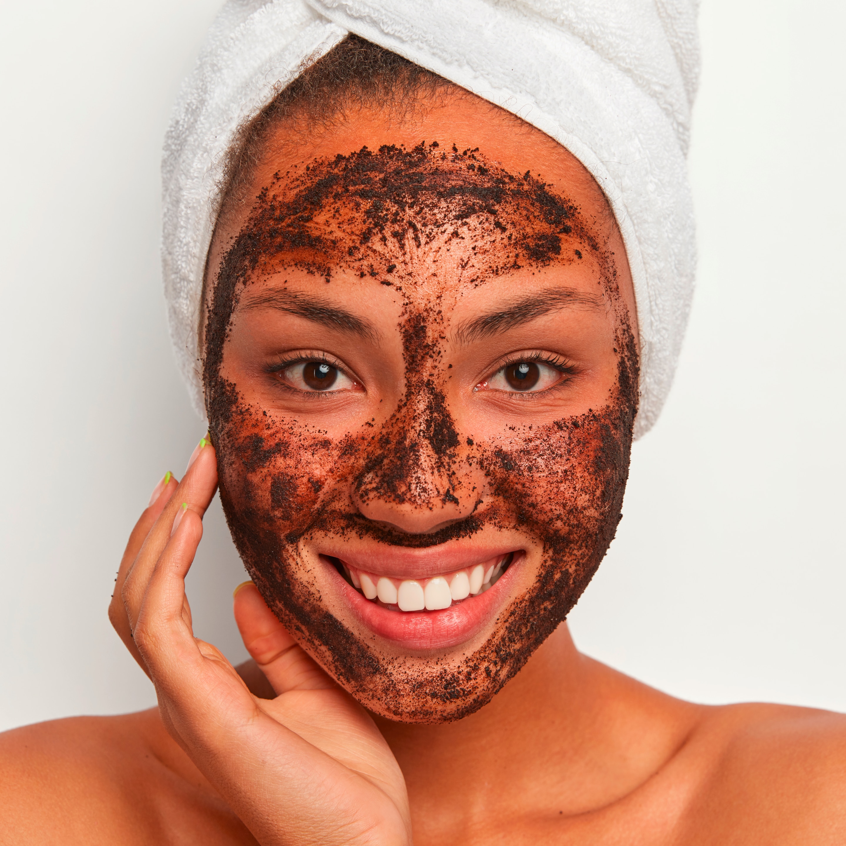 bã cà phê tẩy tế bào chết bằng bã cà phê cô gái quấn khăn tắm trên đầu với khuôn mặt thoa bã cà phê