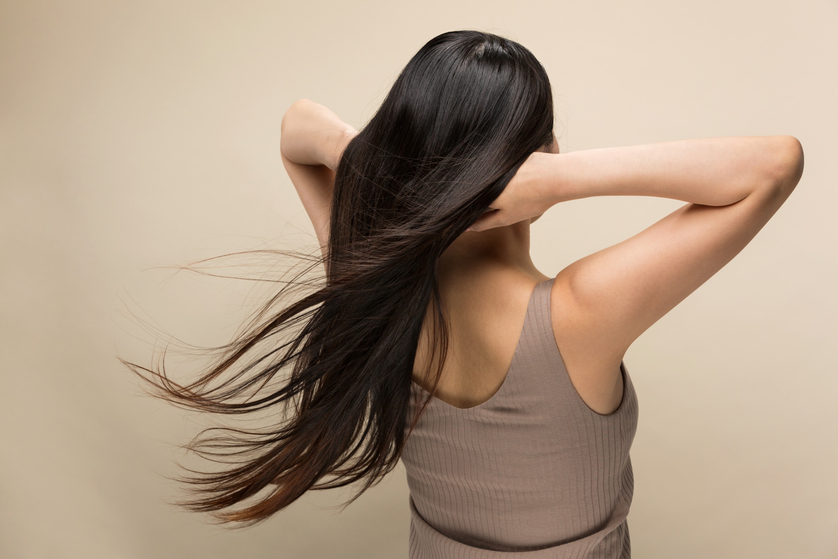 bã cà phê thuốc nhuộm tự nhiên cho tóc tối màu ảnh chụp sau lưng cô gái mặc áo ba lỗ màu nâu có mái tóc đen dài