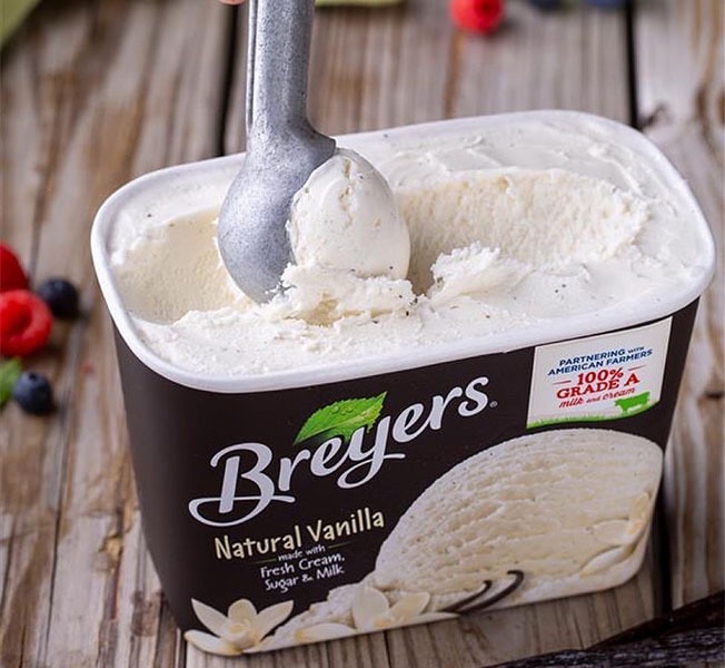 A tub of Breyers Natural Vanilla being scooped.