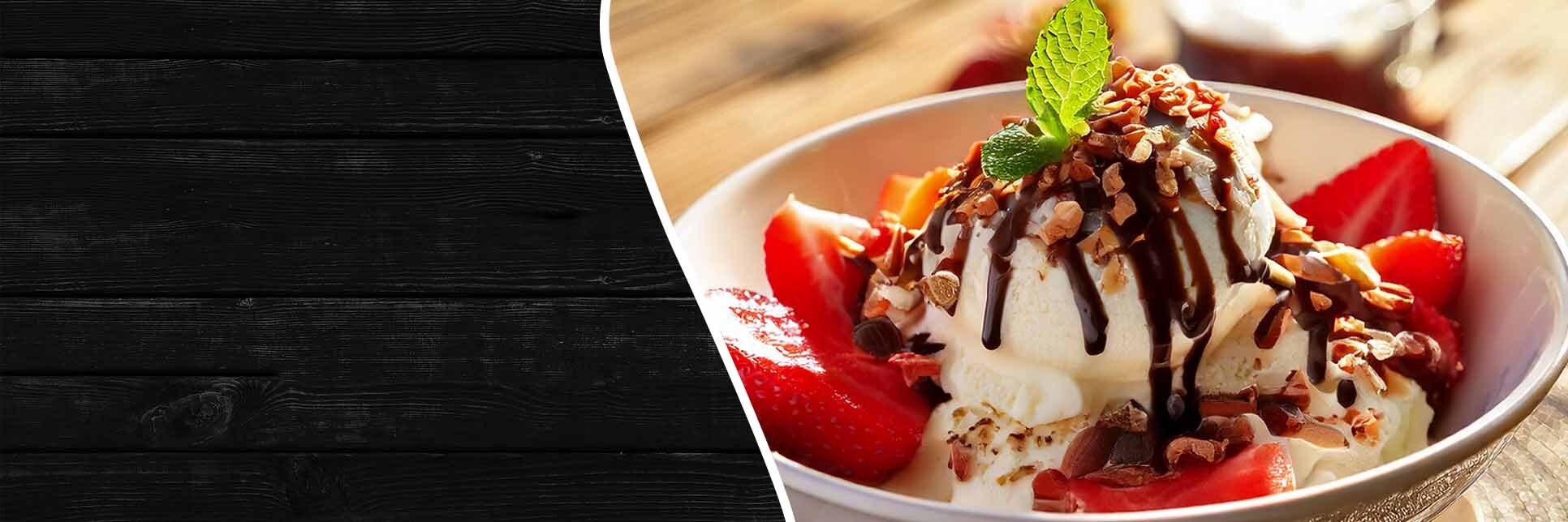 Bowl of ice cream garnished with chocolate syrup and crushed nuts.