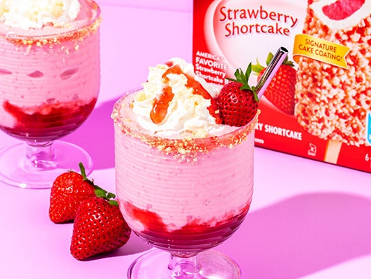 Strawberry shortcake milkshake decorated with strawberries and whipped cream.