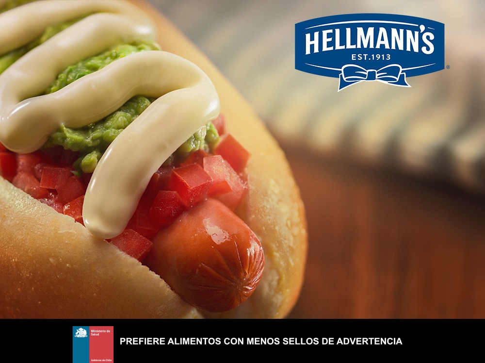 Someone sqeezzing mayonnaise on a sandwich