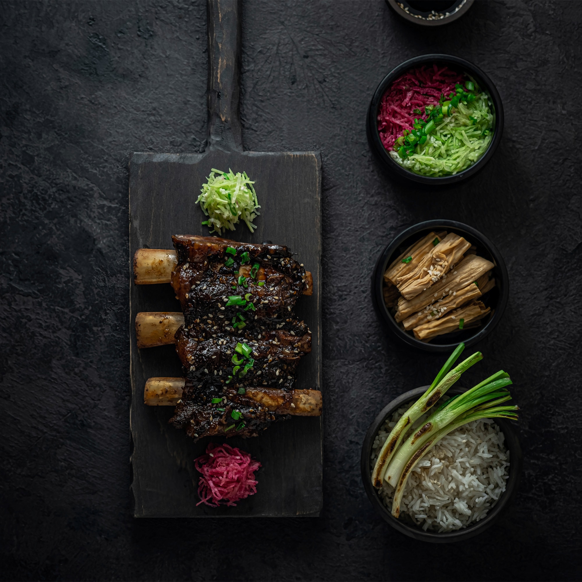 Roast beef on a flat stone pan with herbs on the side