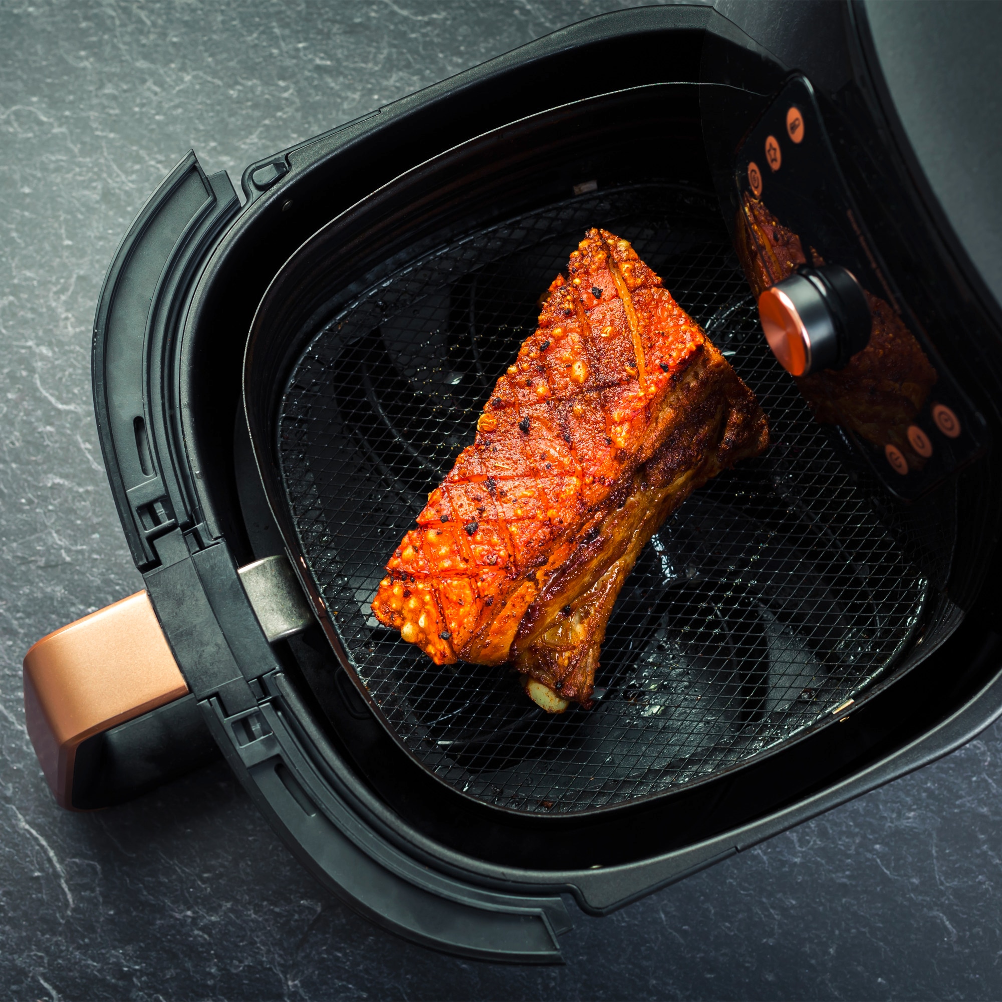 Beef inside an air fryer witha gold handle