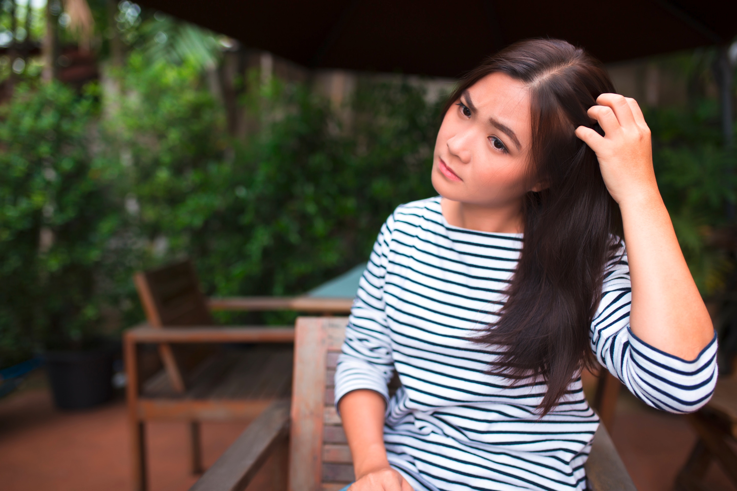 Woman scratching her itchy scalp.