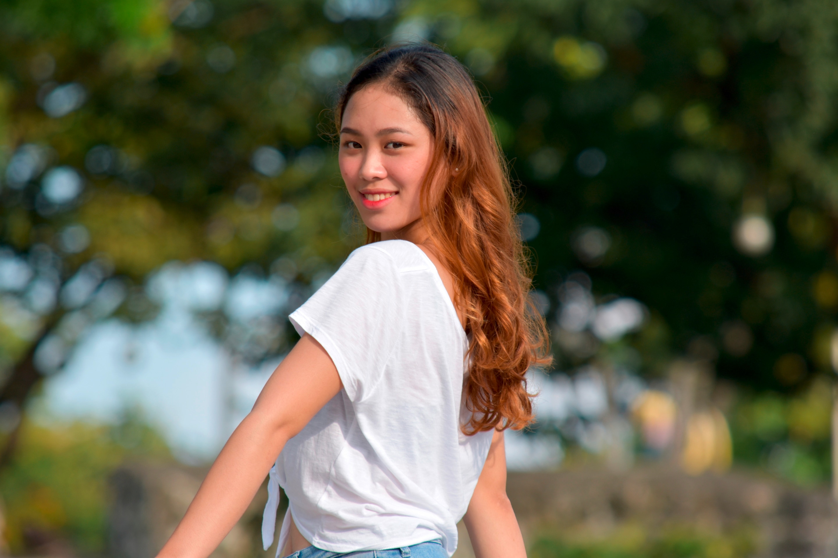 A portrait of woman with long, dyed hair smiling at the camera.