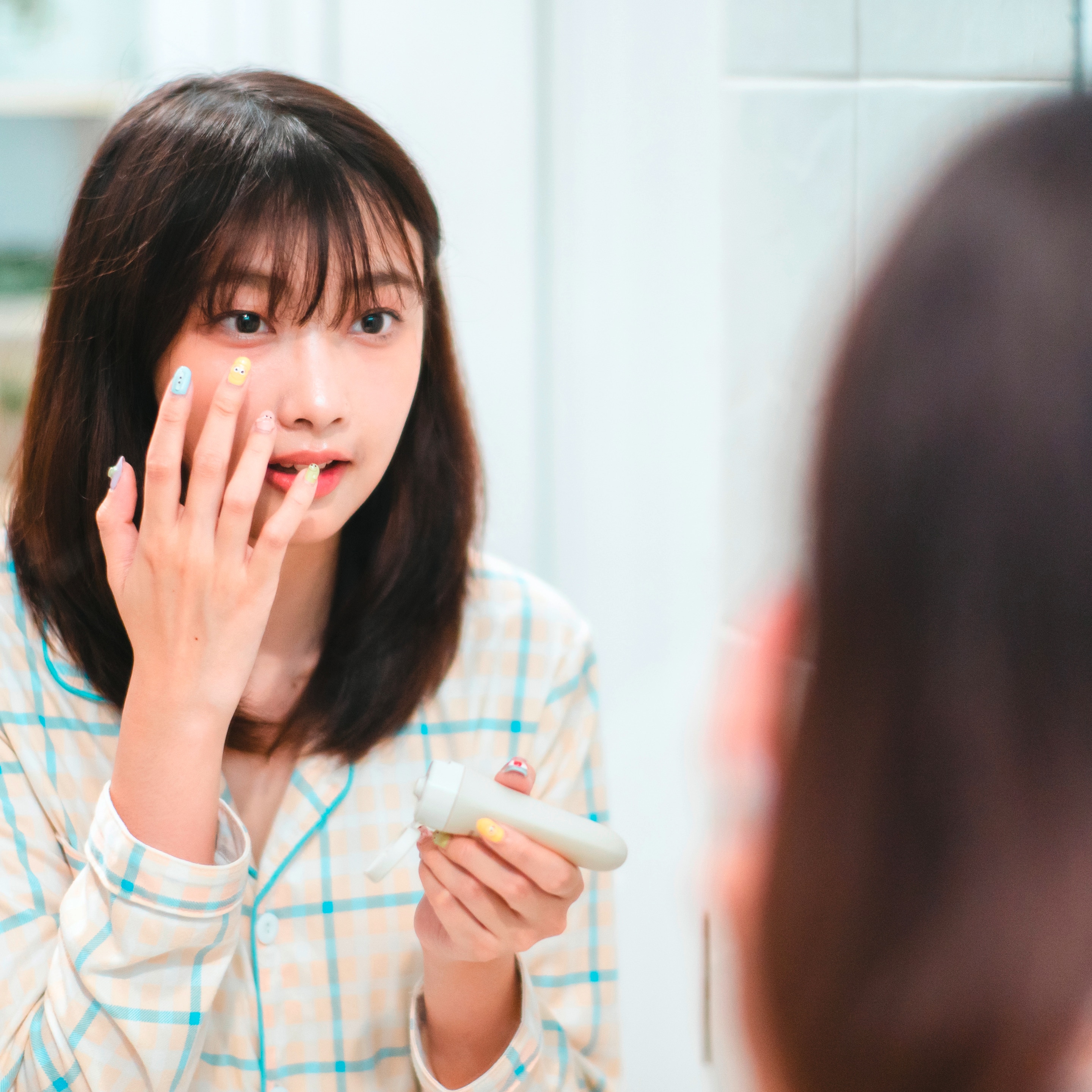 Woman applying skincare on her face.