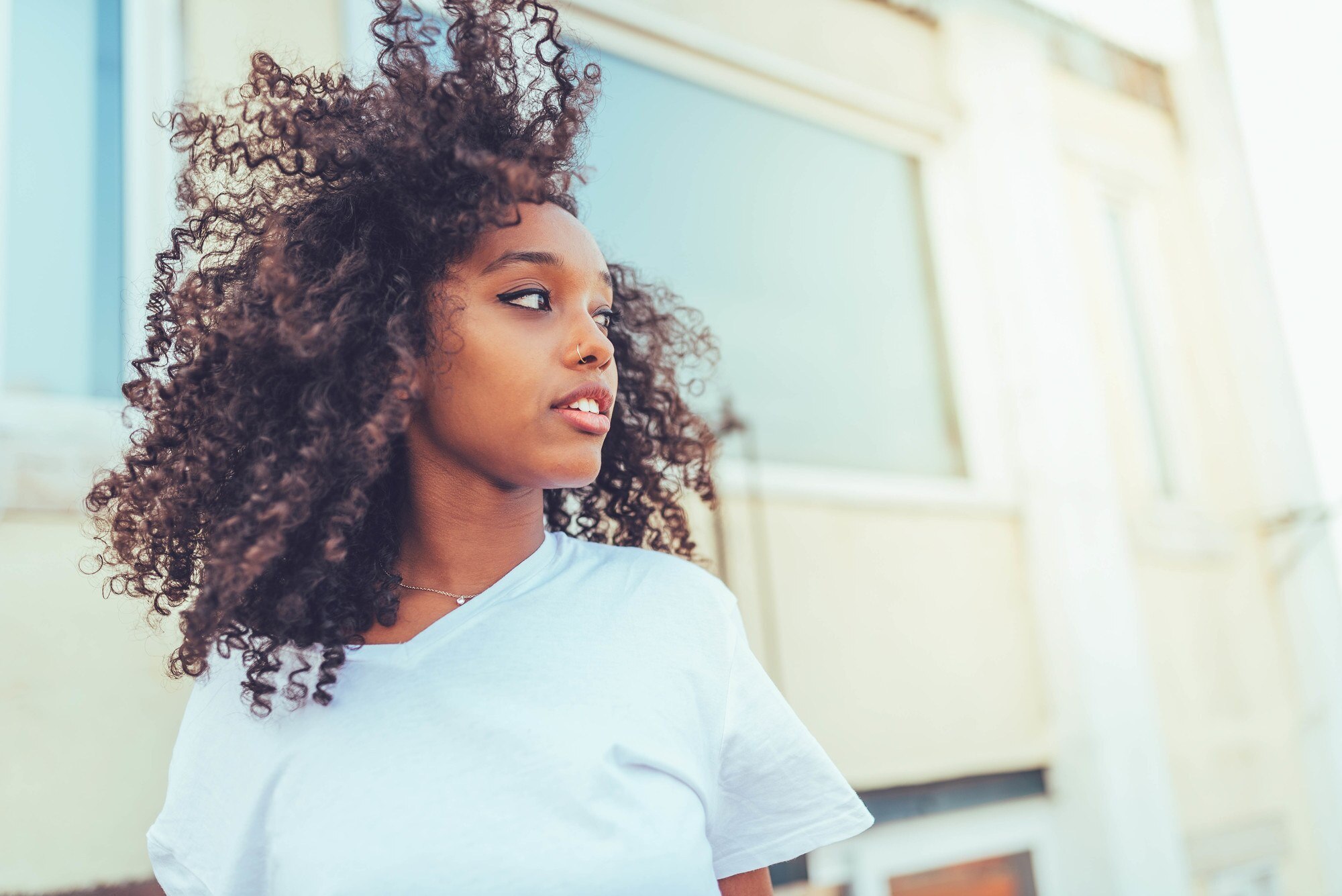 hair products for summer: woman with long, defined curly hair