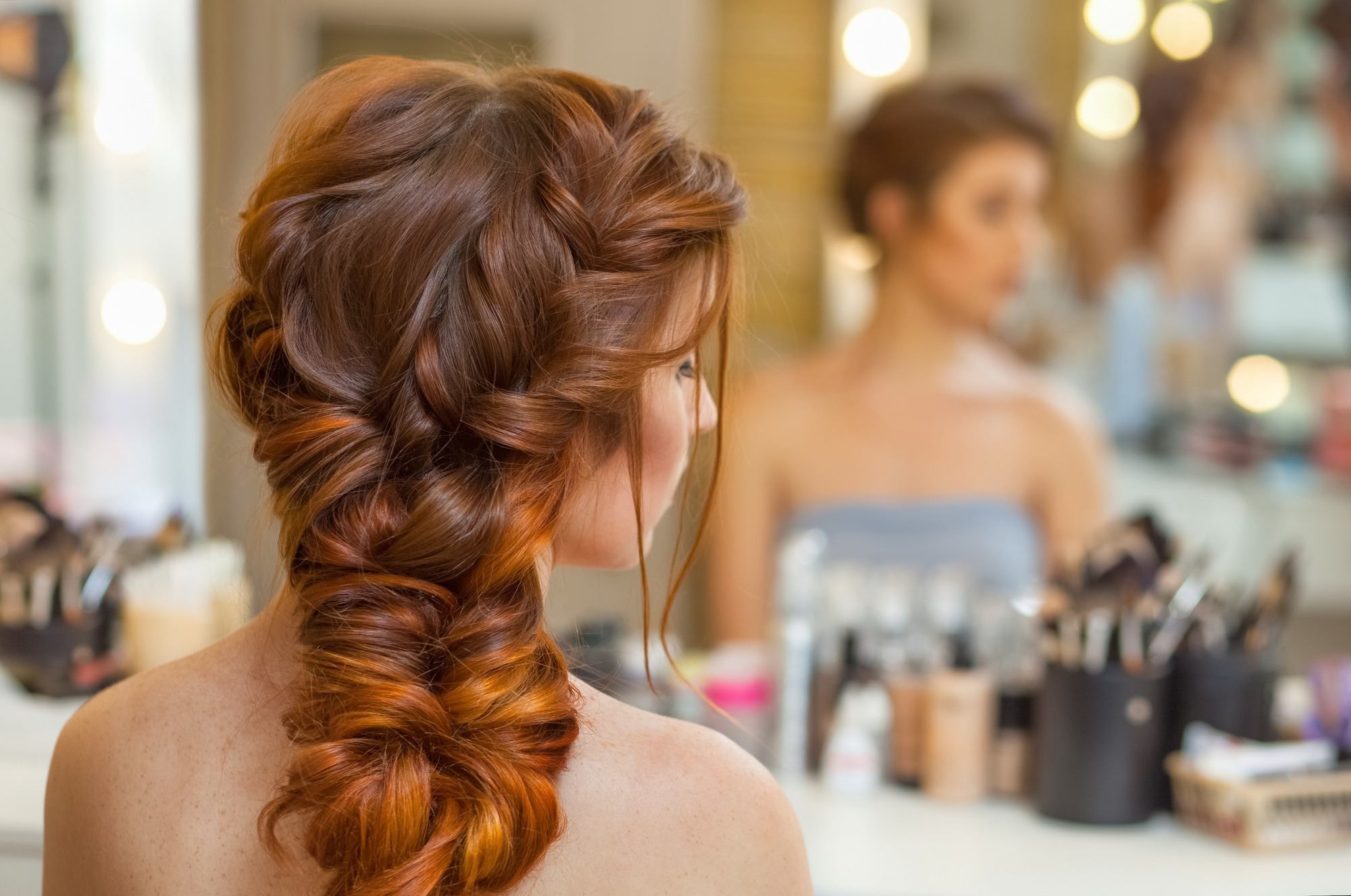 Girl with long, red hair, French braid and fish tail braid hairstyle