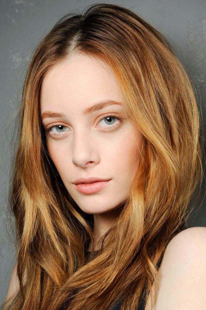 Model with long light auburn highlighted hair.