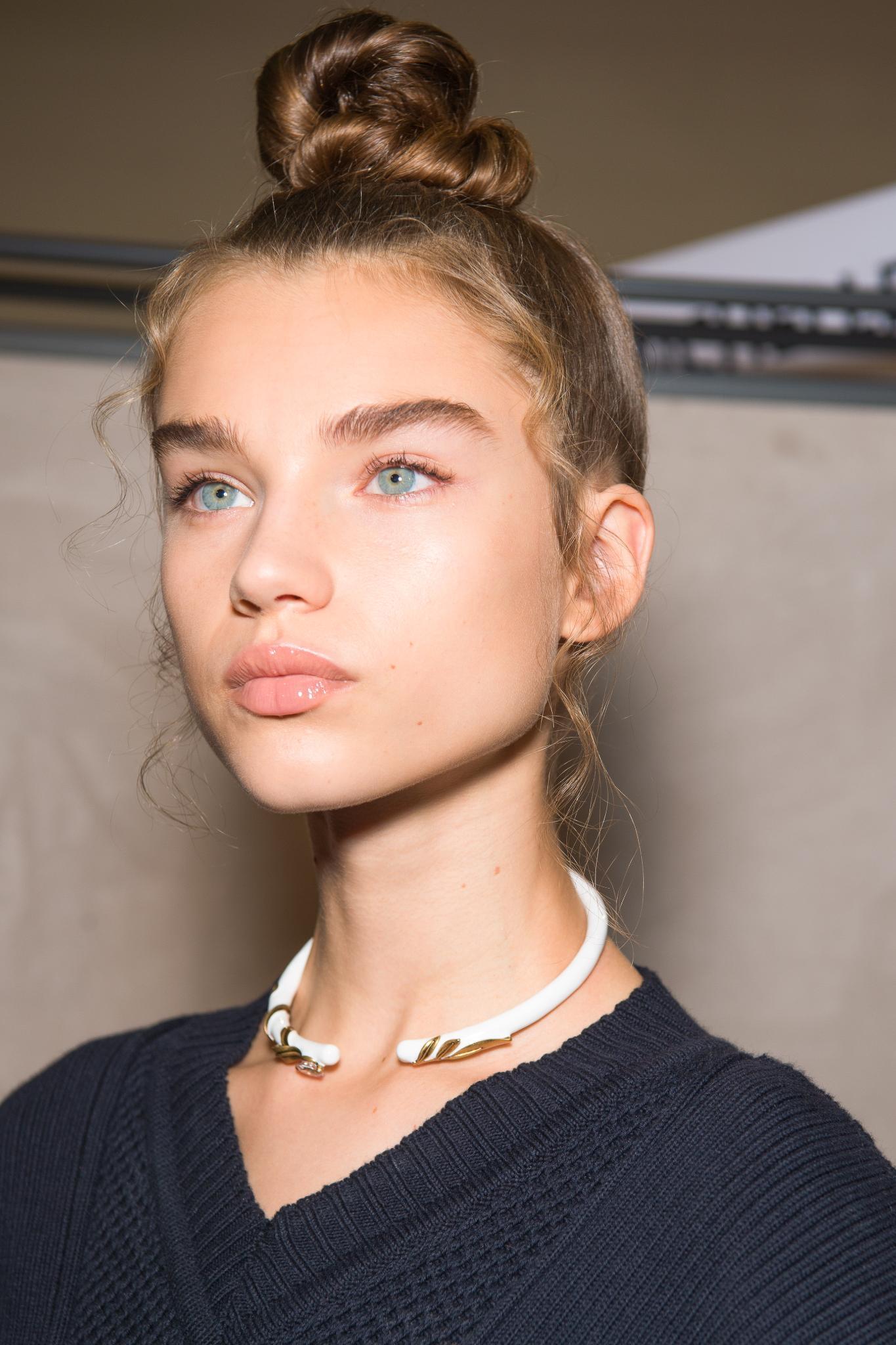 Close up of woman with dark honey blonde high top knot bun seen at Fendi SS19 runway show.