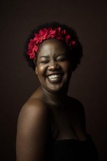 woman with an afro and red flowers