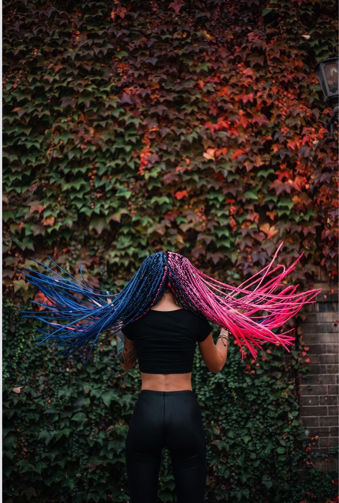 TikTok hairstyles: woman with long braided hair that's half bright pink and half blue