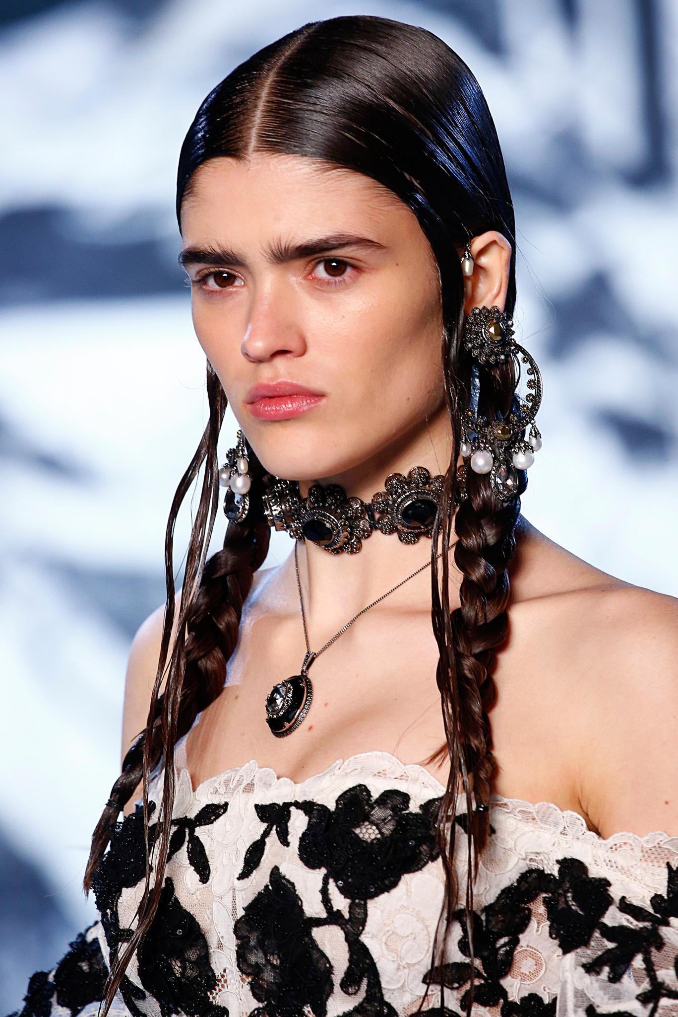 New hairstyle: Model with long dark brown wet look hair in pigtail braids at Alexander McQueen SS19 show.