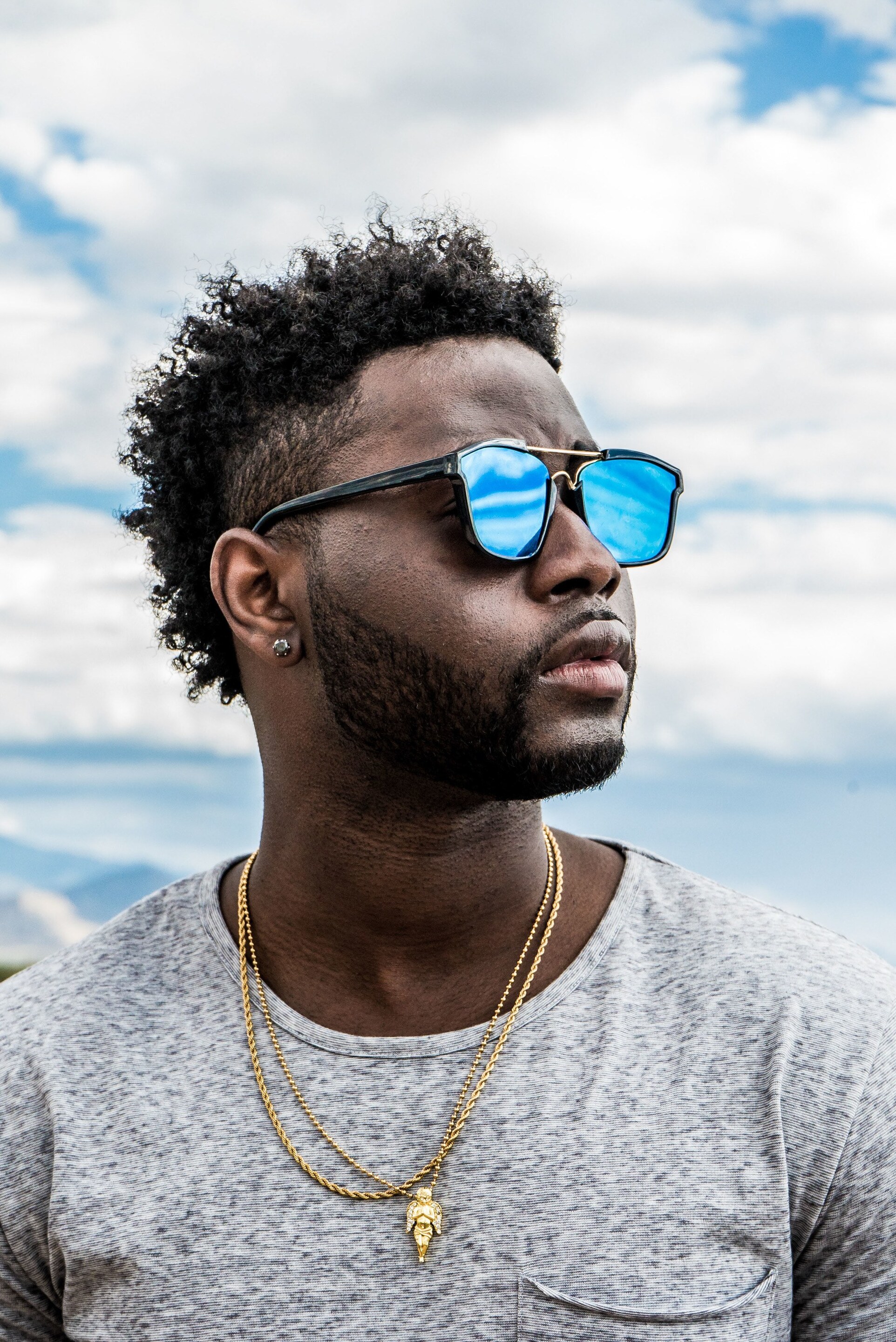 Man wearing shade and a curly hairstyle for men