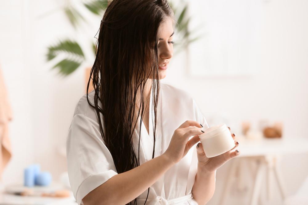 dry hair: woman applying product onto her hair