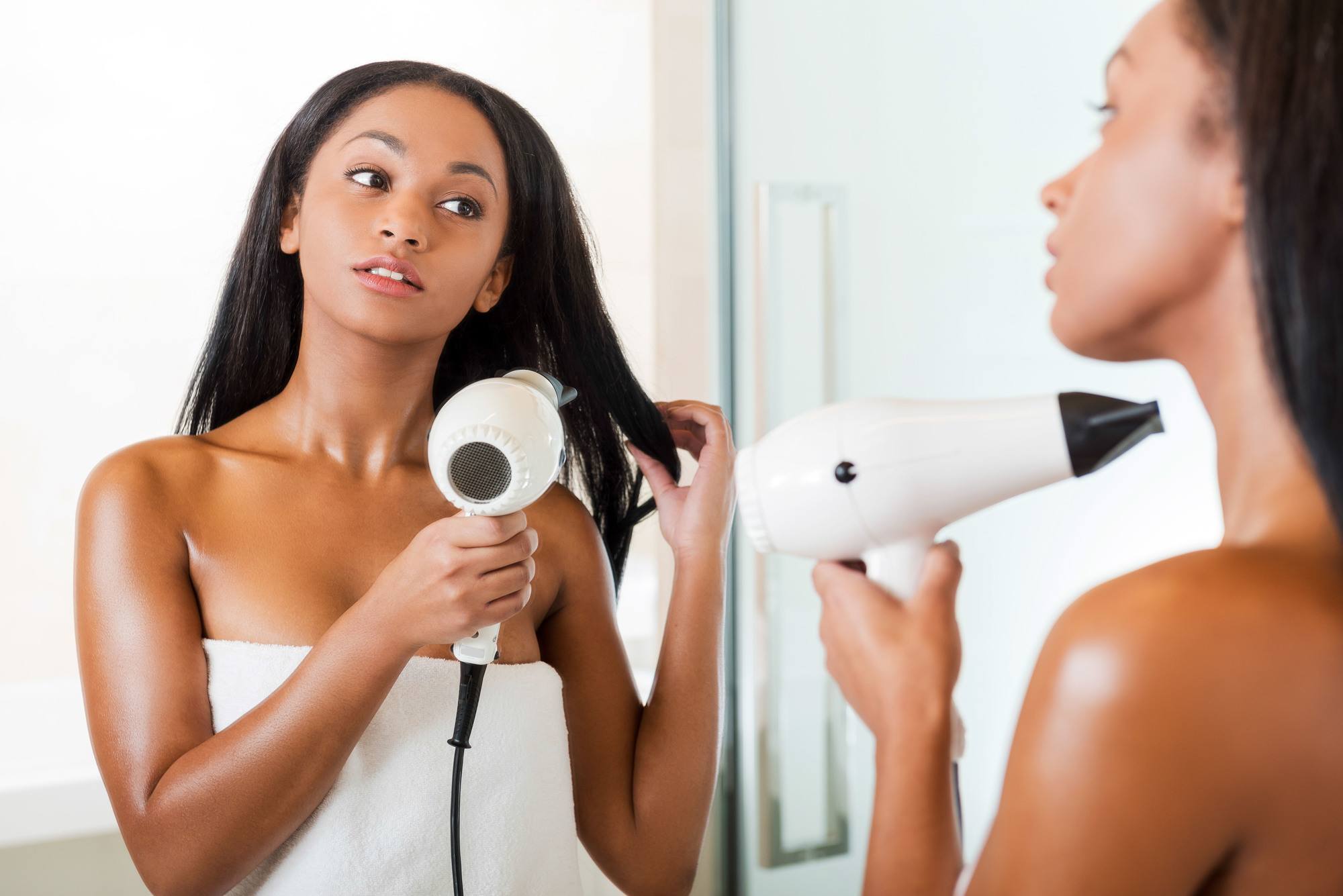 woman blowdrying her hair