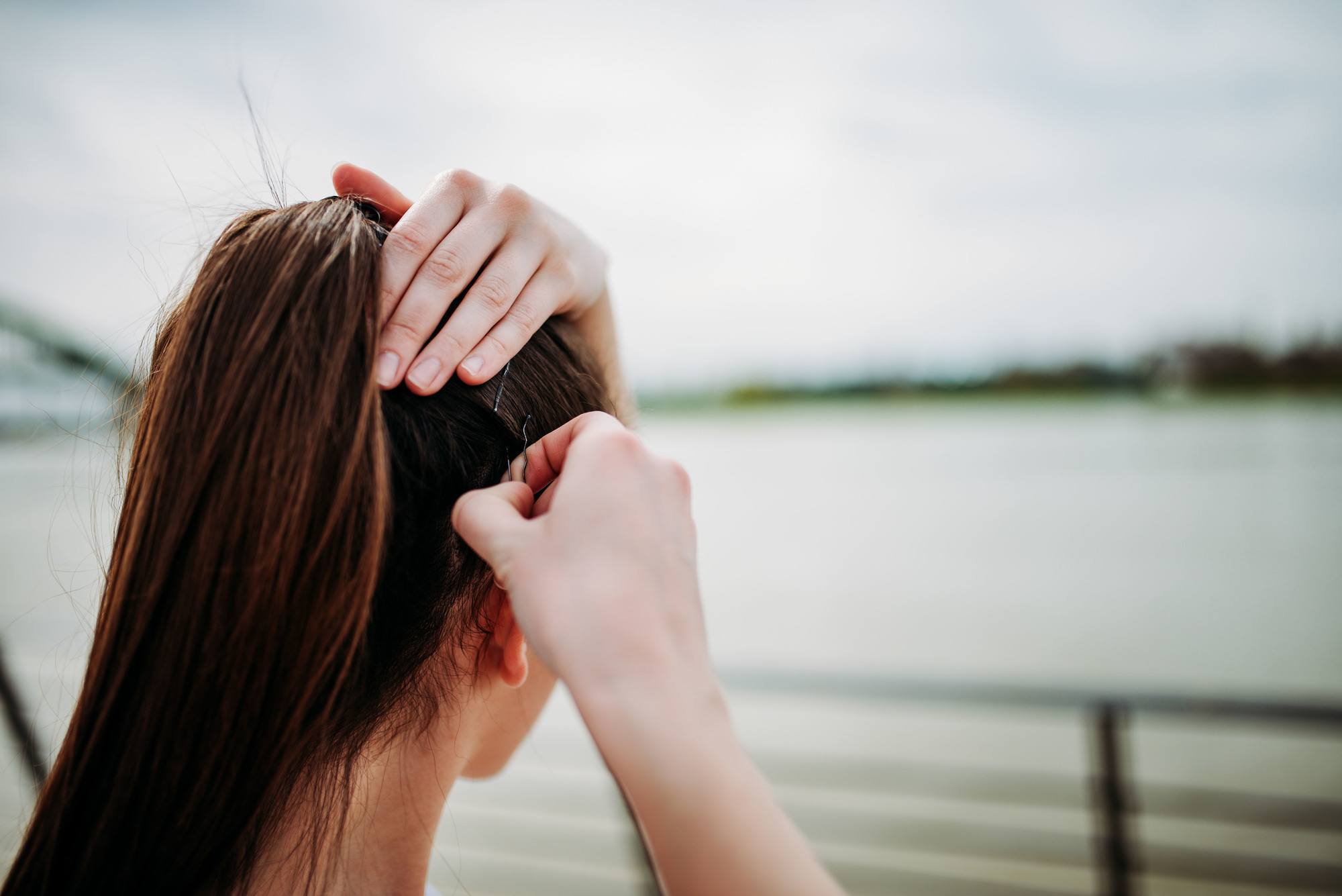 woman with long brown hair in a high ponytail and bobby pins