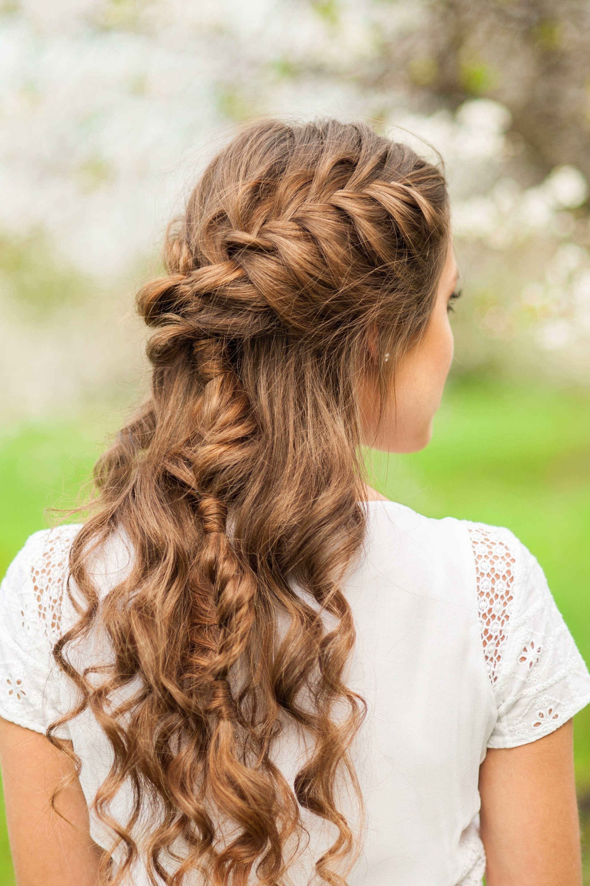greek-inspired hairstyle: woman with long wavy brown hair and loose french braid hairstyle