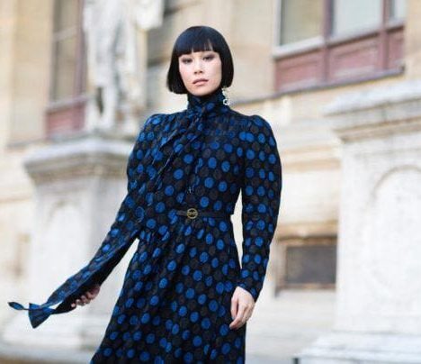Fringe hair: Asian woman with dark brown straight blunt bangs and blunt bob wearing dark patterned dress in street style picture.