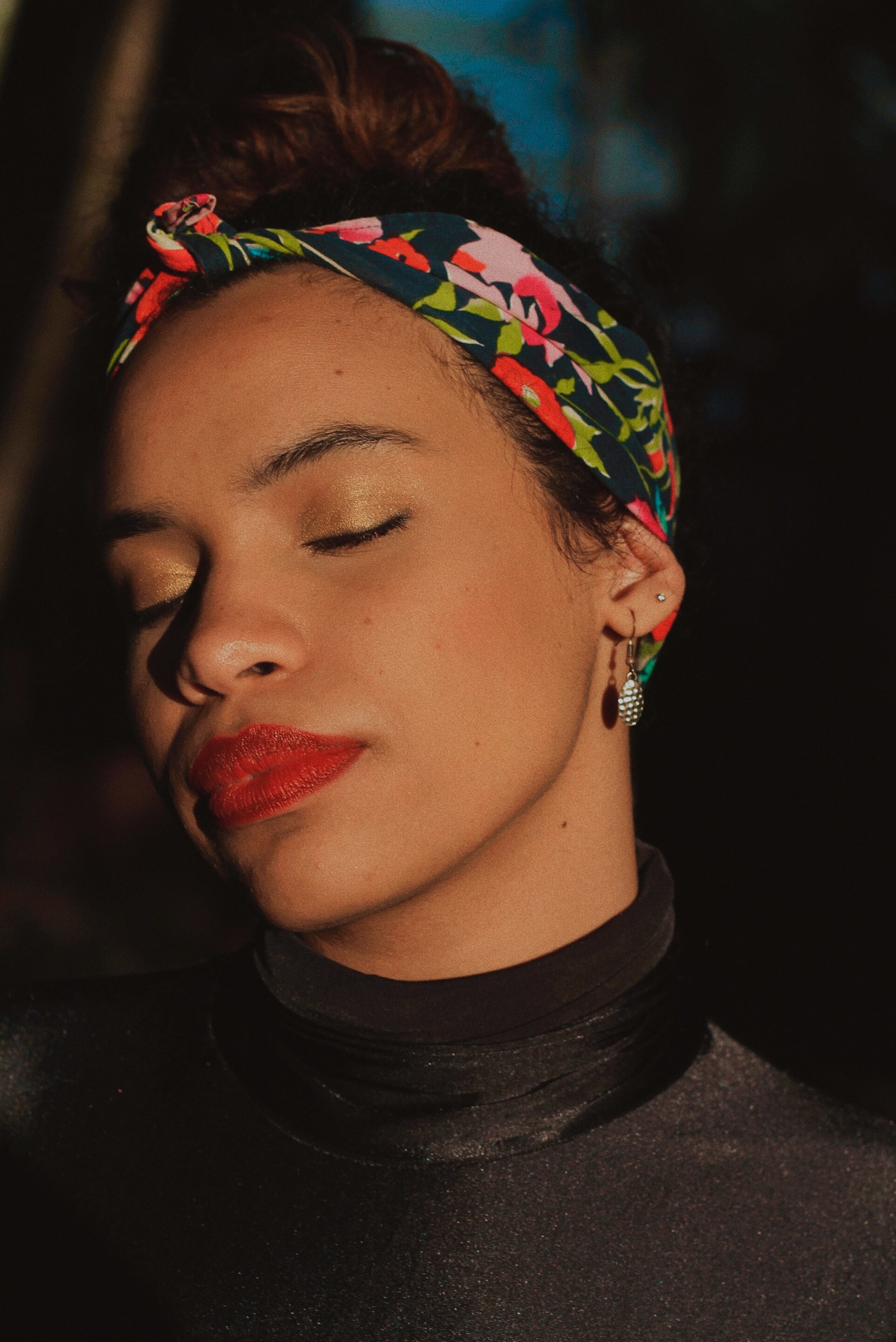 woman with a big printed headband and a bun