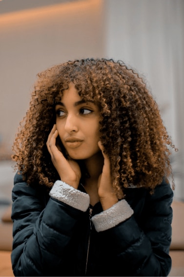 dry shampoo: woman with long dark curly hair and caramel highlights