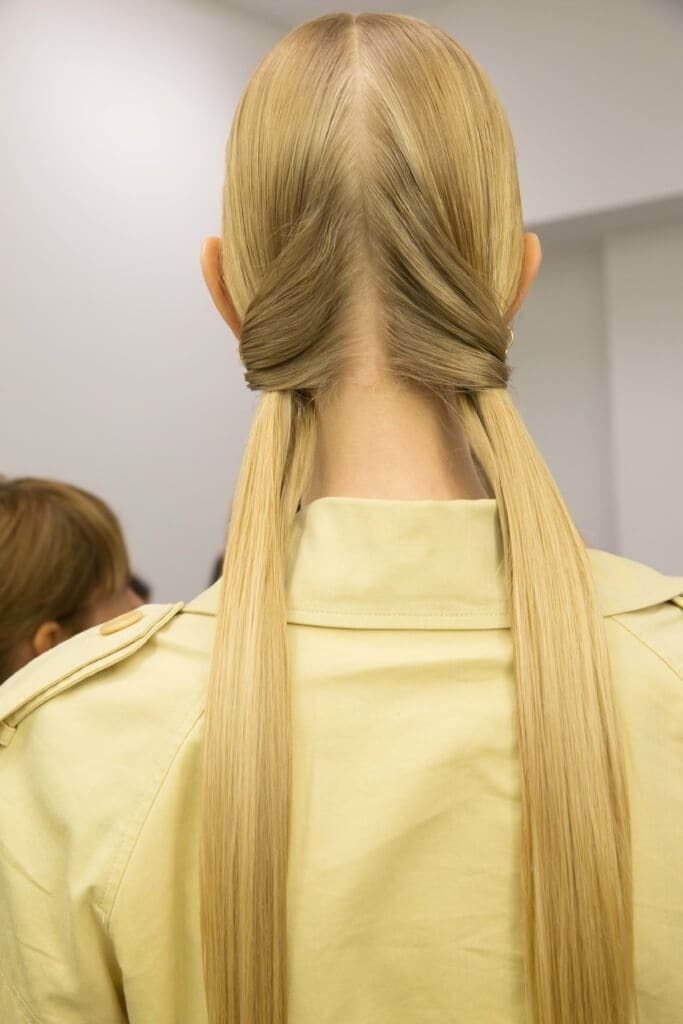 Straight hairstyles: Woman with long straight blonde hair in twisted low pigtails at Marni SS16 show.