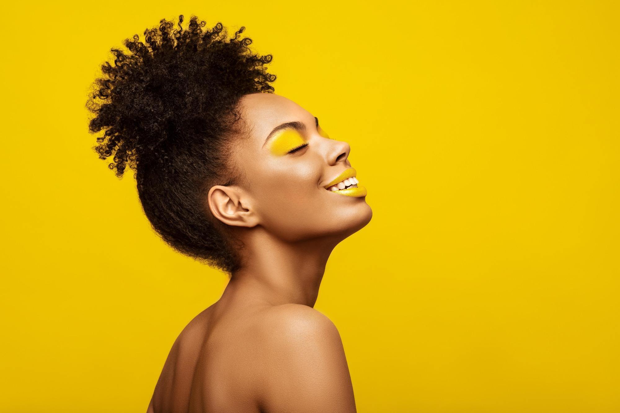 Woman with natural curls tied in a high puff hairstyle