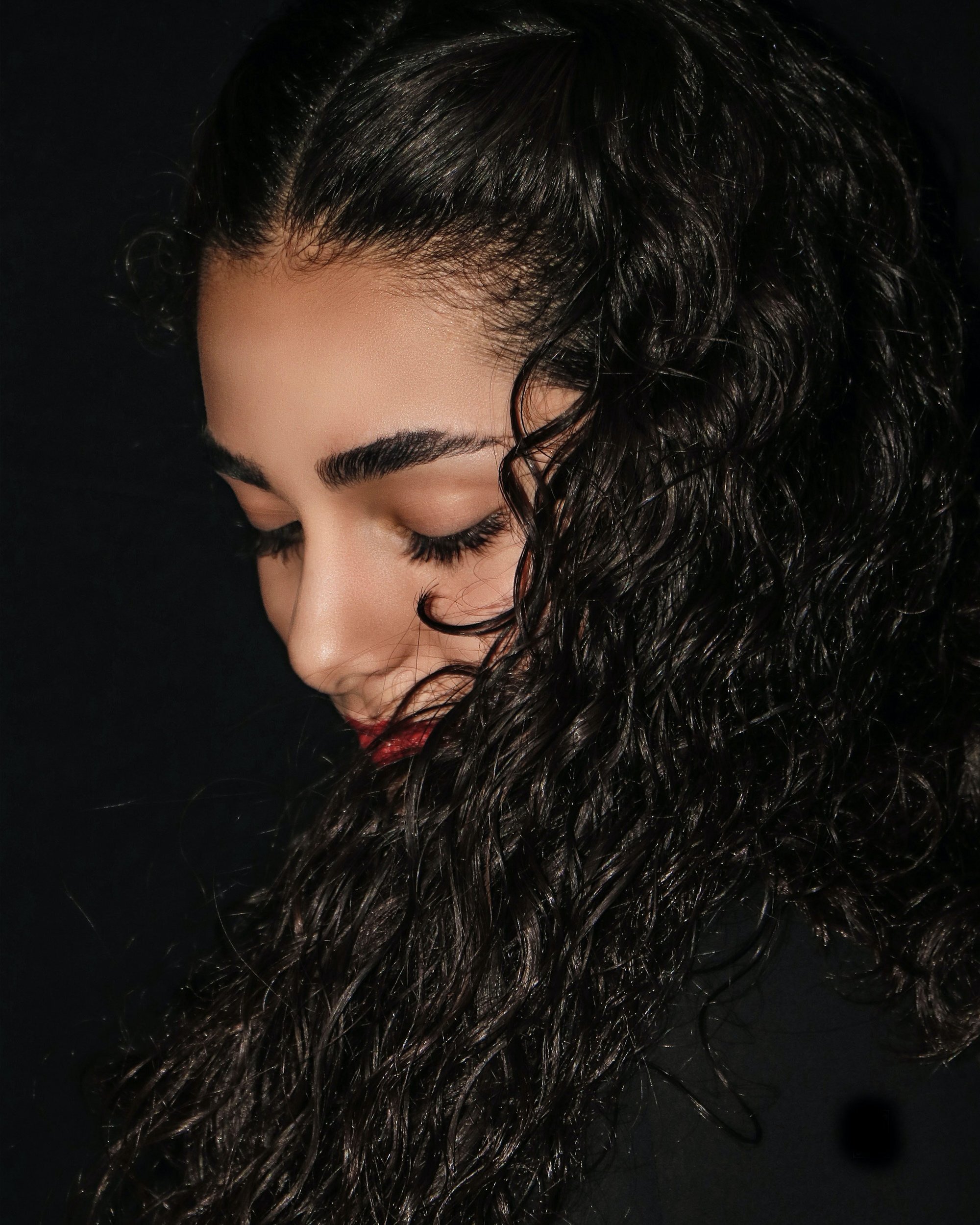 Woman with curly side-parted hair