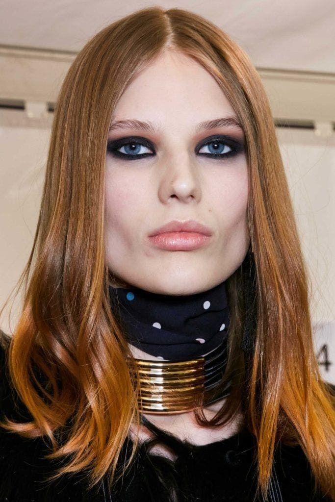 Red hair: Model with straight medium length cinnamon hair wearing a stacked metal choker.