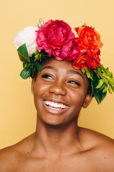woman wearing a big flower crown accessory, with white and red flowers