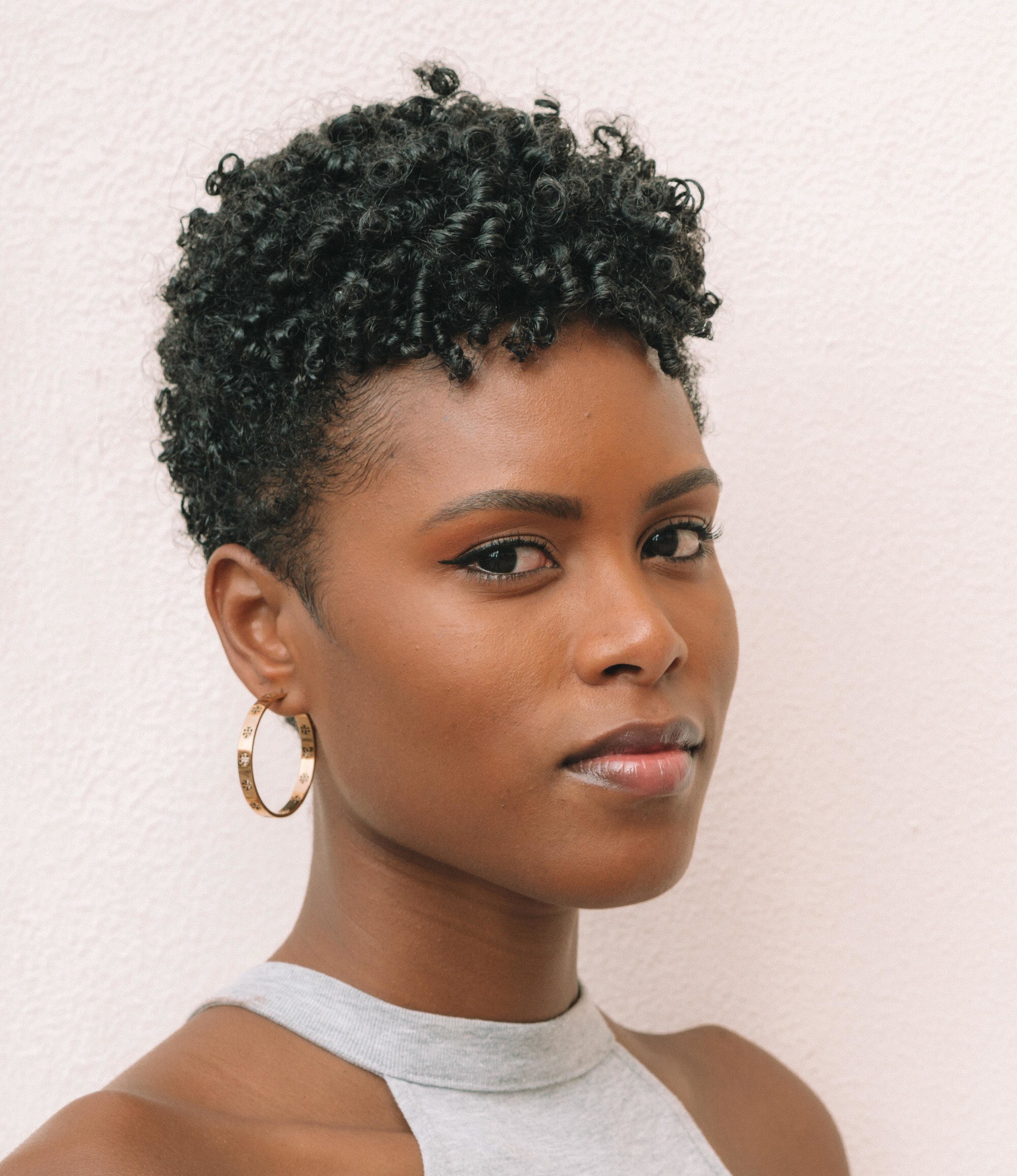 woman with a very short haircut styled in curls