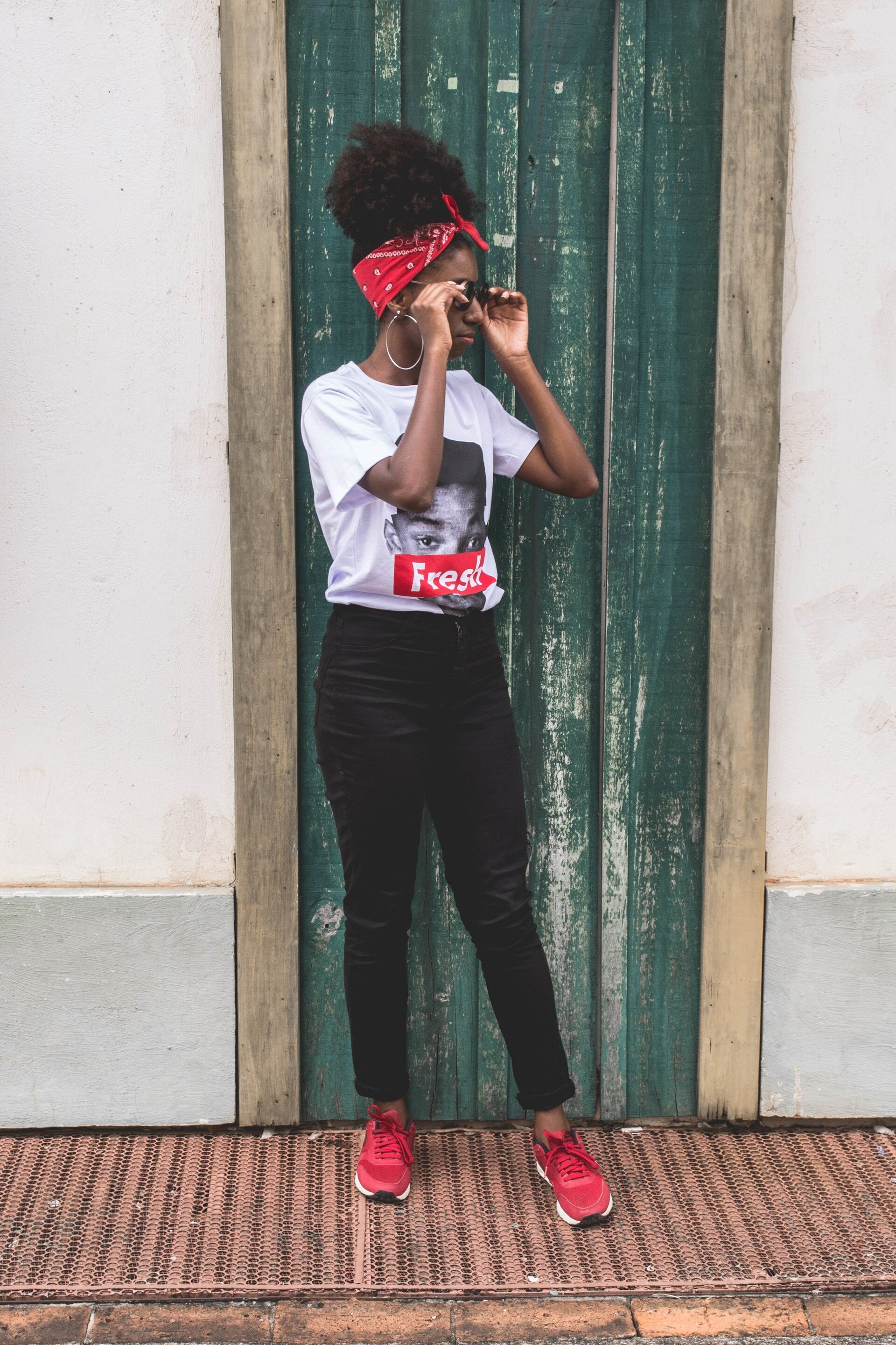 woman with a high puff hairstyle and a bright red bandana wrapped around the hairline