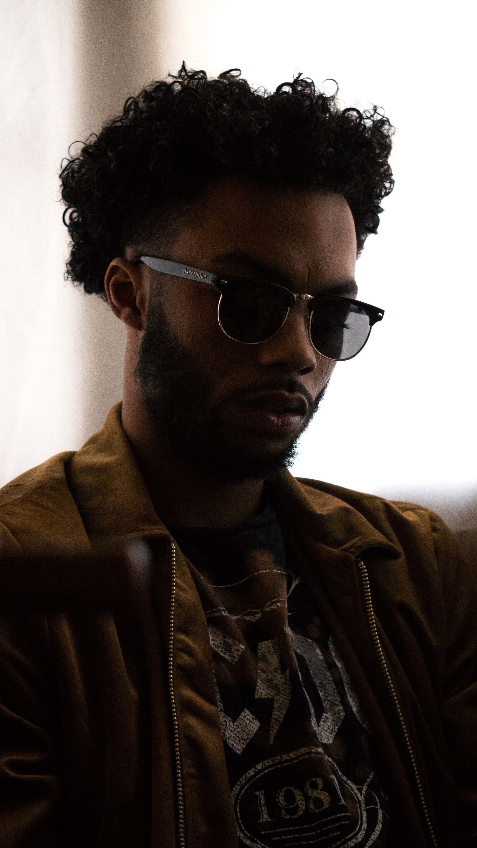 man with short natural curly hair and sunglasses
