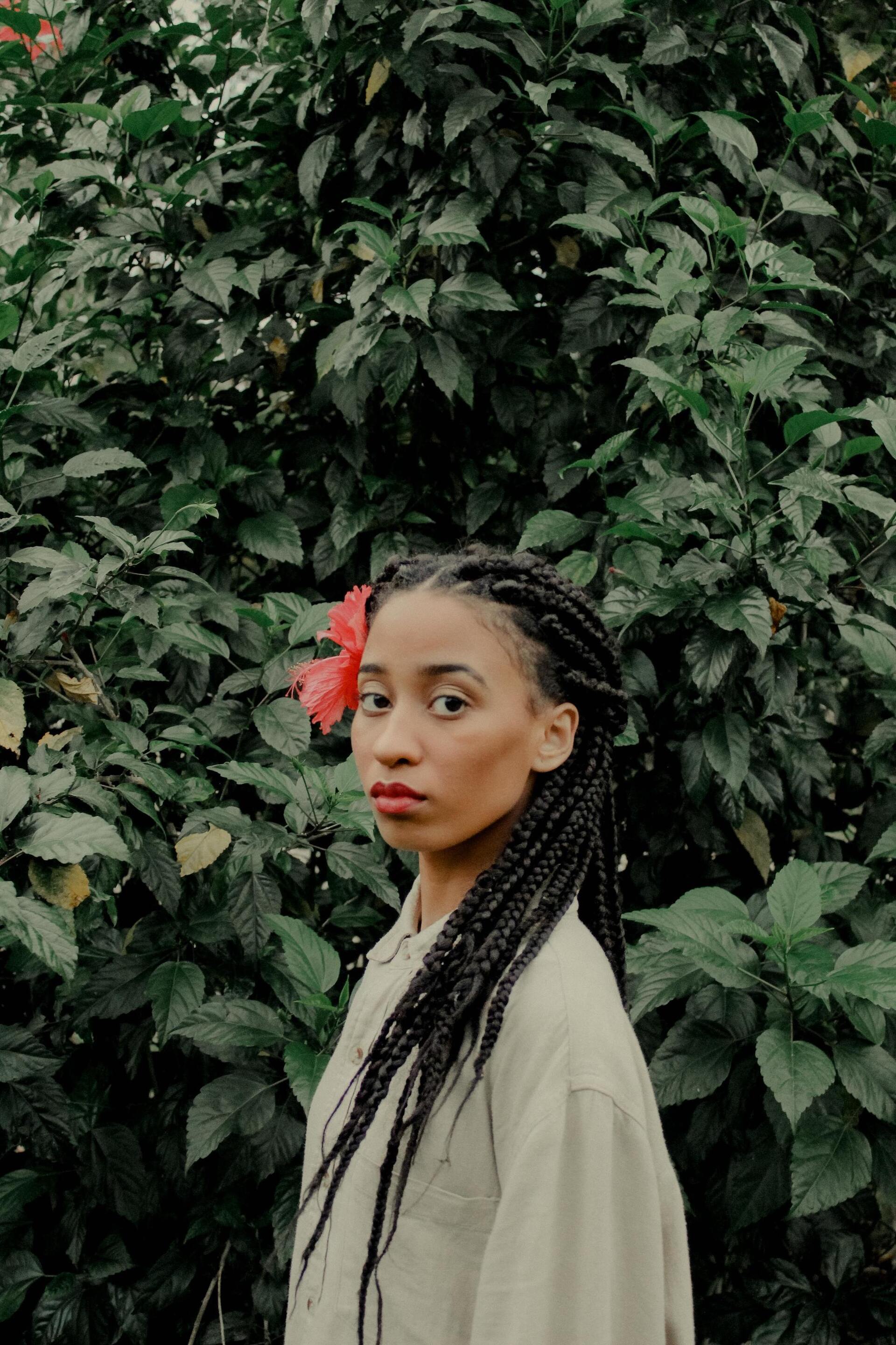 woman with long braids and a flower in her hair inspired by cottagecore