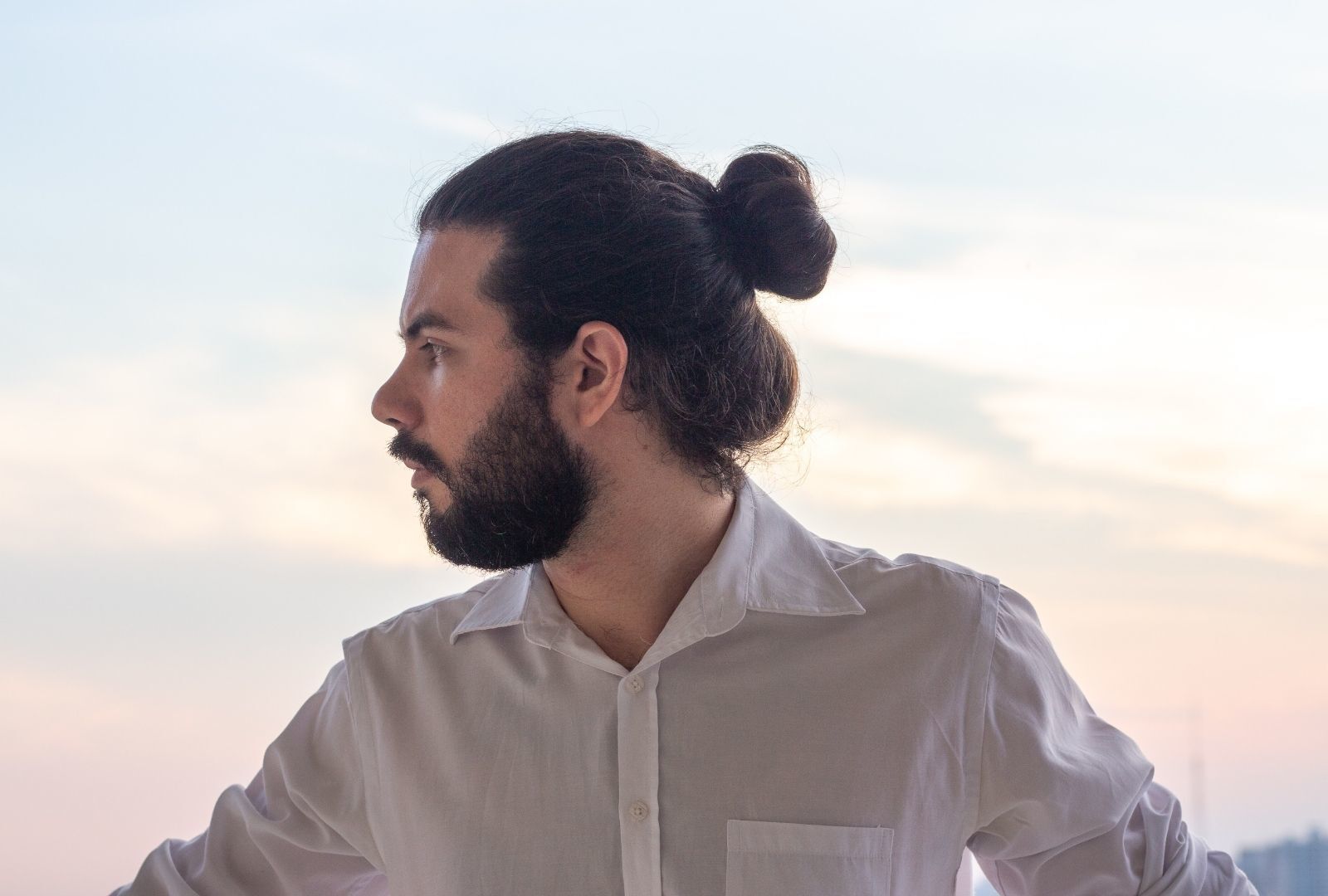 man with a beard and a man bun hairstyle