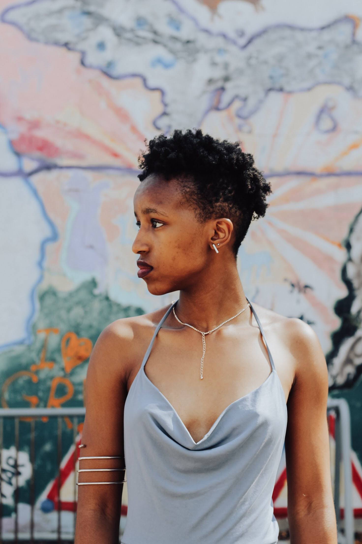 woman with naturally curly hair, cut into a pixie cut with undercuts