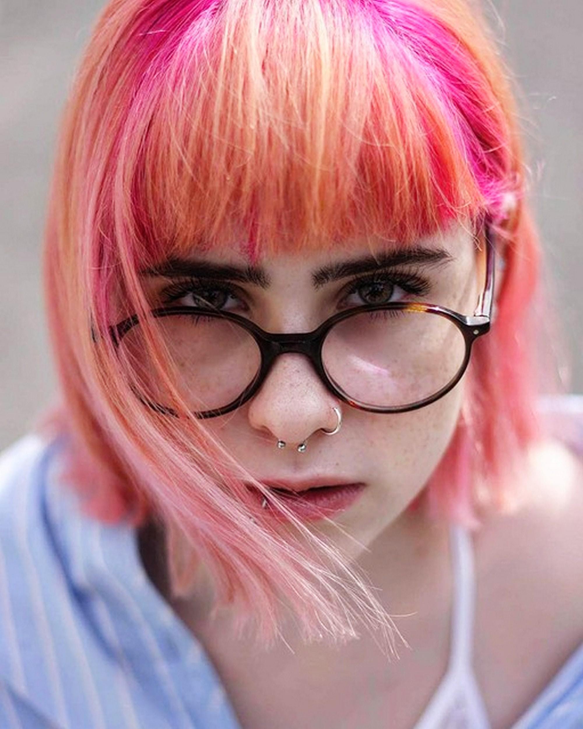 TikTok hairstyles: woman with short straight hair that's dyed peach and pink