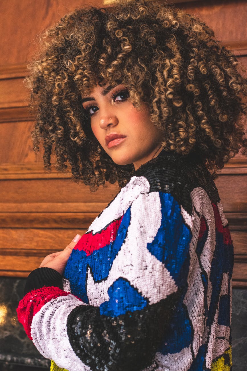 woman with big natural hair afro curls blonde highlights