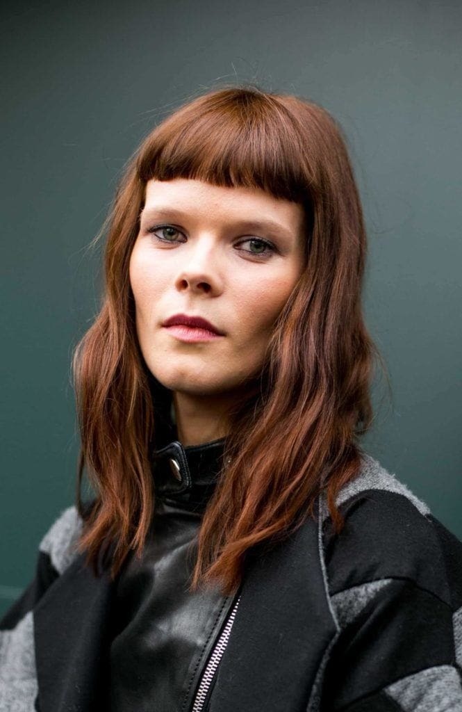 Model with medium length wavy hair with micro fringe.