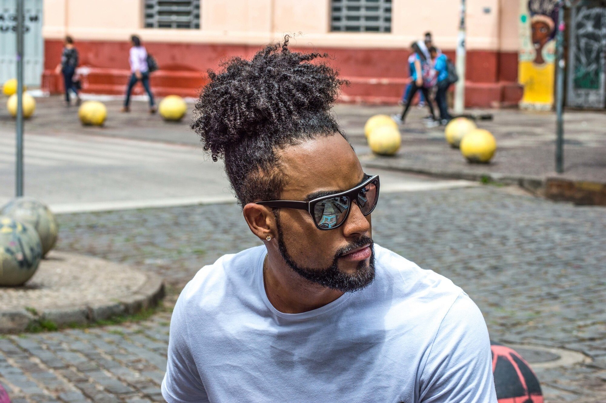 Man with curly hair tied in a ponytail