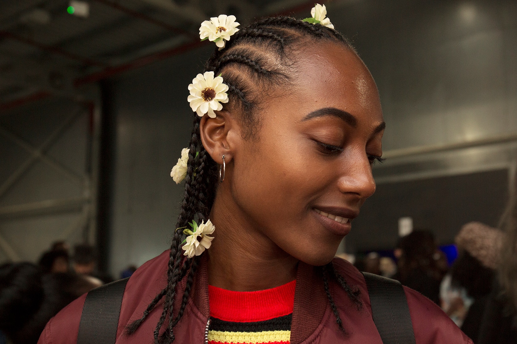 Cornrows: Woman at AfroPunk with hair in cornrow braids with sunflowers placed throughout her hair.